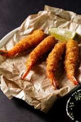 Closeup Crispy fried shrimp with lime on parchment paper