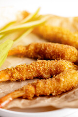 Crispy fried shrimp with lemon wedges on brown paper