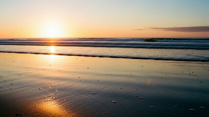 Obraz premium Golden Sunset Over the Ocean Waves on a Sandy Beach.