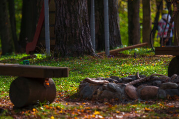 Wooden benches and campfire site in autumn forest recreation area