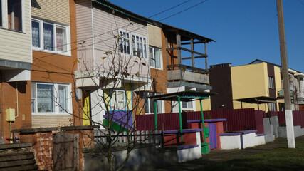 Colorful houses along a quiet street with clear skies and visible balconies in a residential area during the day