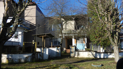 House located in a residential area with trees and a swing set during a clear day in winter