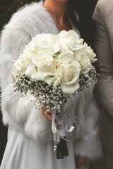 Ein Brautstrauß aus weißen Rosen und Schleierkraut.