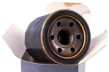 Old used car oil filter in a cardboard box. Isolated background.