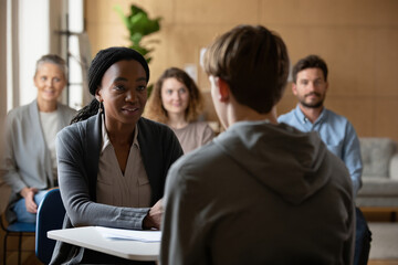 Calm African American female counselor listening empathetically to client