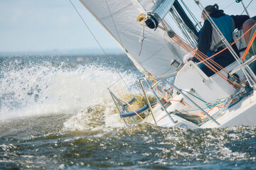 Fototapeta premium Sailing regatta in the Gulf of Finland at sunny day, sailing yacht competing in a race, splashing water from under the boat, teamwork, board the boat