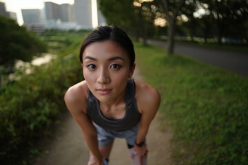 Young woman with prosthetic running blade preparing for a determined outdoor run