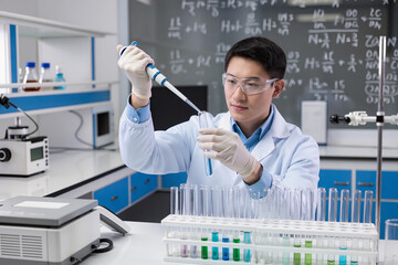 Researcher is dropping the reagent into test tube, with chemical equations background, in laboratory
