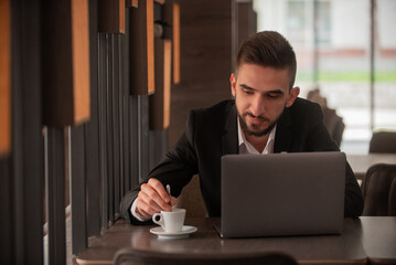 A Young happy business man working on a laptop at office or cafe restaurant.