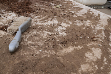Cleaning tools on a dusty surface with soil and debris, showcasing the importance of maintenance in outdoor environments and gardening tasks