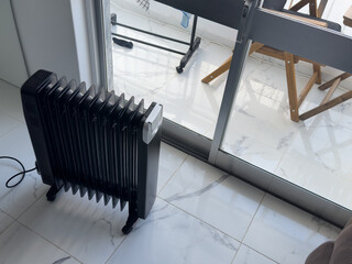 Electric oil-filled radiator for heating home and maintain comfortable temperature standing in cozy...