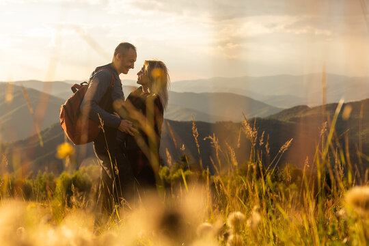 travel to mountains, tourists hikers with backpacks at sunset enjoying panoramic view