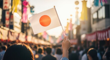 Hand Waving Small Japan Flag at Vibrant, Sun-Drenched Street Festival