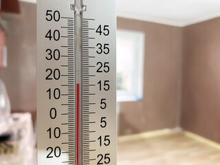 Thermometer showing indoor temperature inside a freshly renovated and unfurnished room