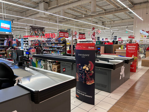 A checkout area at an Auchan supermarket with product displays, cash registers, and promotional signage photographed in Gdynia, Poland December 6, 2025