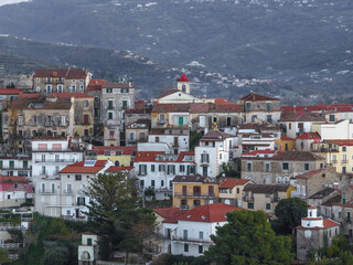 Aerial view of the townscape with buildings clustered, hinting at ancient stories beneath terracotta roofs and the church spire piercing the skyline, Agropoli, Campania, Italy.