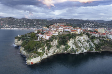 Aerial view of the historic Castello Aragonese perched on a cliffside, its ancient stones contrasting with the azure sea, Agropoli, Campania, Italy.