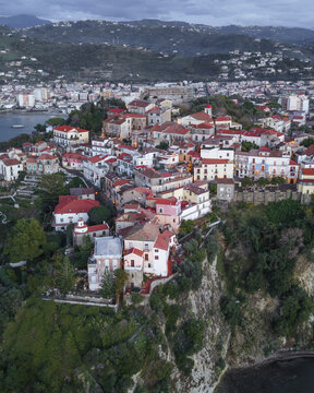Aerial view of the vibrant town cascading down the cliffs towards the sea, with the harbor and distant mountains completing the picturesque panorama, Agropoli, Campania, Italy.