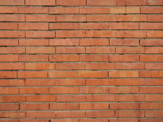 full frame modern red brick wall texture seamless pattern background. A detailed
close-up of a neat, contemporary red and orange clay brick facade arranged in a uniform
horizontal running bond pattern