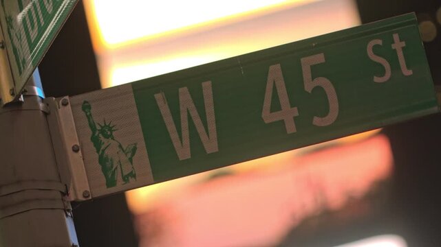 Close-up Lit West 45th Street Sign in Manhattan at Night, illuminated by Times Square bilboards
