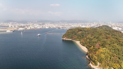 Obraz premium Ujina Island, Minami Ward, Hiroshima Bay, Japan Coastline: 4K Aerial Drone Footage of Forest Mountains, Rural Island, Autumn Colours, Beaches, Clear Ocean Water, Hiroshima City Skyline, Harbour, Port