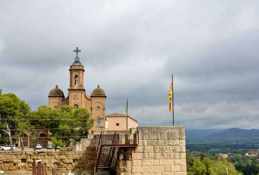 Sant Crist sanctuary (Bas&iacute;lica del Santo Cristo de Balaguer) with catalonia flag in cloudy day. Beautiful mountain landscape in Balaguer, Lleida, Catalonia, Spain. 