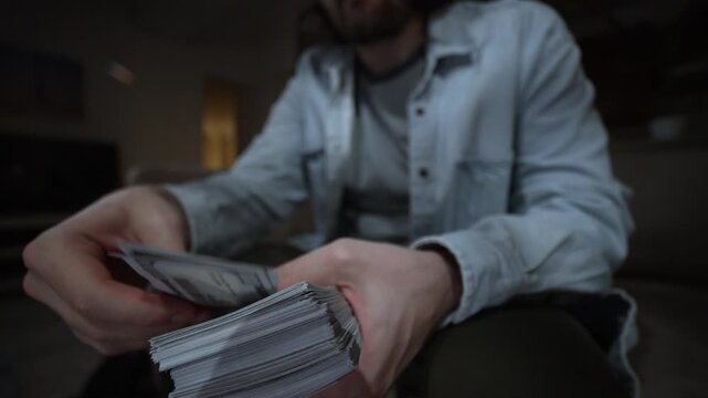 Hand pulls single banknote from pile and throws money toward camera as bold cash gesture for wealth success. Throwing Money From Stack. Cash Flex Showing Wealth and Hustle. Rich man with a lot of cash