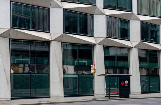 Empty London TFL bus stop in the City of London against a modern office building.