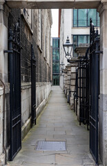 Fototapeta premium Narrow alley in the city of London with iron rails and traditional victorian lantern.