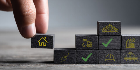 Construction and real estate development process. Hand stacking wooden blocks with construction icons symbolizing planning, building, quality control, and completion. Architecture, engineering, and pr