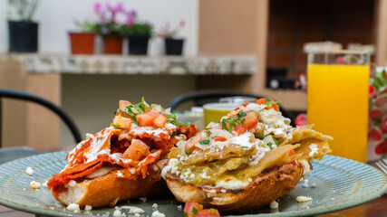molletes chilaquiles mexicanos con salsa roja y verde acompañados de jugo de naranja / Mexican chilaquiles with red and green sauce and orange juice