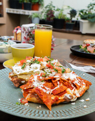 molletes chilaquiles mexicanos con salsa roja y verde acompañados de jugo de naranja / Mexican chilaquiles with red and green sauce and orange juice