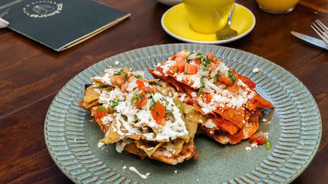 molletes chilaquiles mexicanos con salsa roja y verde acompa&ntilde;ados de jugo de naranja / Mexican chilaquiles with red and green sauce and orange juice