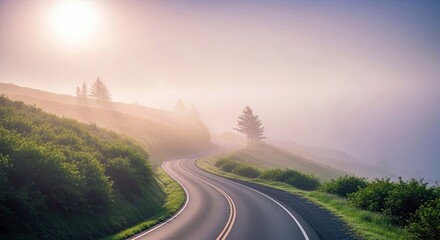 A scenic view of a winding road through a misty, green landscape at sunrise. The road curves through hills with trees and bushes, bathed in soft, warm light.