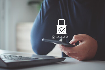Asian businessman using smartphone login secure access on laptop for validate password for online biometric two step authentication to unlock. Business technology on cyber security concept.