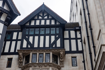 London, UK, 6 December 2025, A detail of Liberty London’s historic mock-Tudor facade, featuring an ornate stone bay window with carved figures, set against a tall modern stone building.