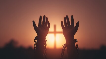 Hands are lifted towards the sky during sunset. Chains are seen on the wrists. A cross stands in the background capturing a moment of reflection and significance.