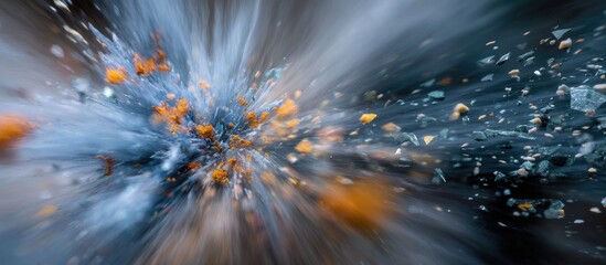 Abstract explosion of blue and orange particles against blurred background