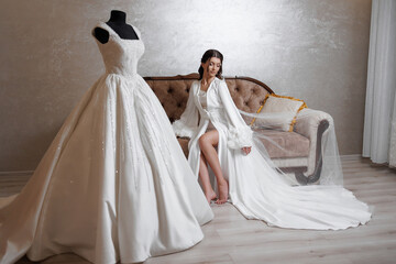 Elegant bride preparing for wedding in bridal suite with stunning gown on mannequin