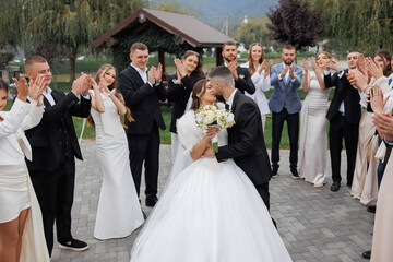Couple celebrates wedding in beautiful outdoor setting surrounded by joyful guests
