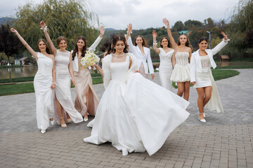 Bride celebrates joyfully with her bridal party in a beautiful outdoor setting