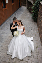 Elegant wedding couple embraces in a charming alley at sunset