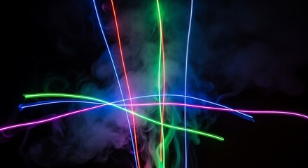 Vibrant neon light trails intersect through smoky darkness, creating a dynamic and colorful abstract display of energy and motion.