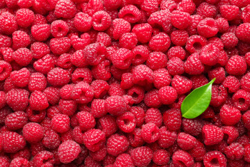 Naklejka premium Fresh ripe raspberries and leaf as background, top view