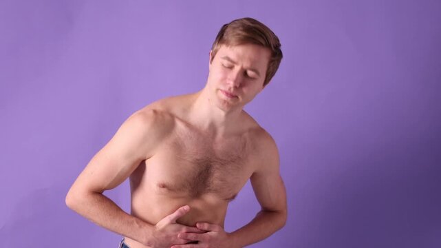 Man suffering from stomach ache on violet background