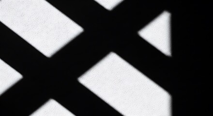 High contrast abstract pattern of intersecting black shadows on a bright white surface, creating a dynamic geometric design.