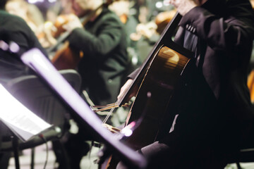 Concert view of contrabass violoncello player with vocalist and musical band during string concert, jazz orchestra performing music, violoncellist cello jazz player on stage in club, music arena hall