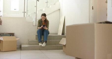 Couple unpacking foyer boxes man entering with lamp making woman on step using phone looking up - Powered by Adobe