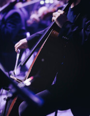 Concert view of contrabass violoncello player with vocalist and musical band during string concert, jazz orchestra performing music, violoncellist cello jazz player on stage in club, music arena hall © tsuguliev