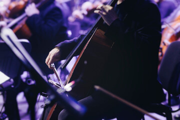 Concert view of contrabass violoncello player with vocalist and musical band during string concert, jazz orchestra performing music, violoncellist cello jazz player on stage in club, music arena hall